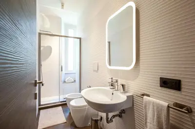a bathroom with a sink and a toilet and a mirror at Confort Collection Trastevere in Rome