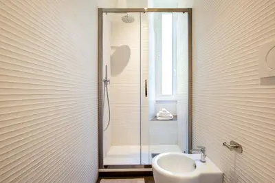 a bathroom with a shower and a toilet and a sink at Confort Collection Trastevere in Rome