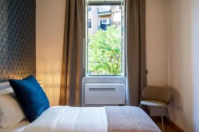 a bedroom with a bed with a blue pillow and a window at Confort Collection Trastevere in Rome