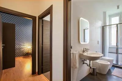 a bathroom with a sink and a toilet and a mirror at Confort Collection Trastevere in Rome