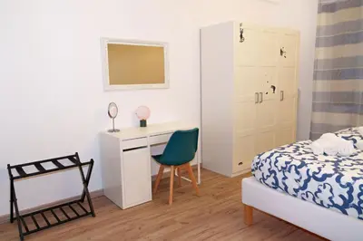 a bedroom with a bed and a desk and a chair at Le Libellule apartment in Rome