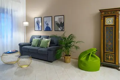 a living room with a blue couch and a clock at Le Libellule apartment in Rome