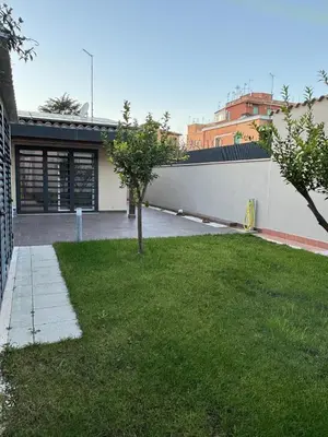 a house with a yard with a tree in it at Villino Ancillotto with garden and parking motorcycle space in Rome