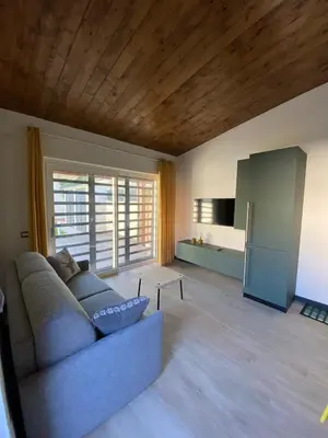 a living room with a couch and a kitchen at Villino Ancillotto with garden and parking motorcycle space in Rome