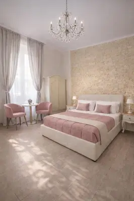 a large bedroom with a large bed and a chandelier at RomAntic Dreams in Rome