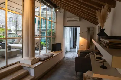 a living room with a couch and a large window at Historical Palace Apartment with Large Terrace in Rome