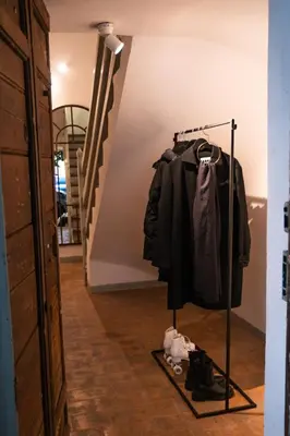 a clothes rack in a hallway with a coat and shoes at Historical Palace Apartment with Large Terrace in Rome