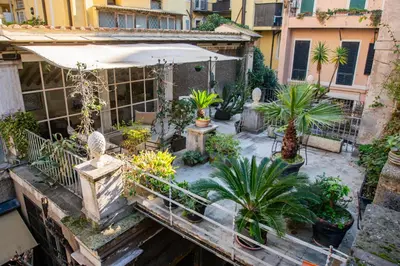 an outdoor garden with potted plants and an umbrella at Historical Palace Apartment with Large Terrace in Rome