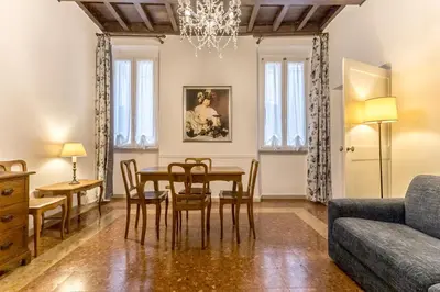 a living room with a table and chairs and a couch at Casa Iside in Rome