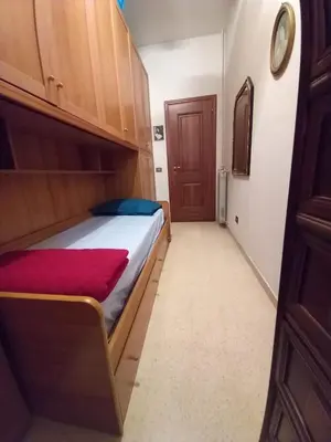 a bedroom with a bed and a wooden cabinet at Spacious Apartment in City Centre in Rome