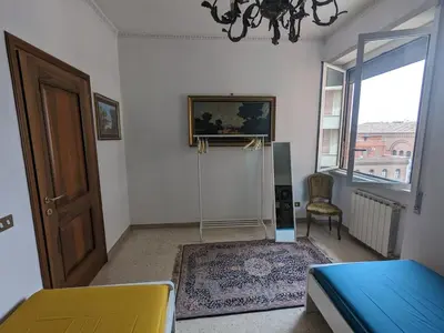 a bedroom with a bed and a door and a chair at Spacious Apartment in City Centre in Rome