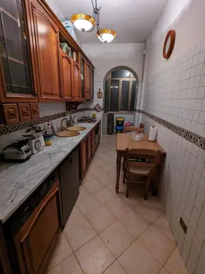 a kitchen with wooden cabinets and a table in it at Spacious Apartment in City Centre in Rome