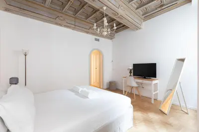 a white bedroom with a bed and a tv at Modern and Bright Flat - Rome City Center in Rome