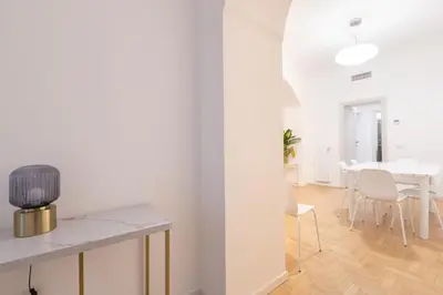 a white living room with a table and chairs at Modern and Bright Flat - Rome City Center in Rome
