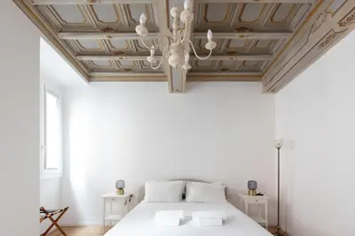 a bedroom with a white bed and a wooden ceiling at Modern and Bright Flat - Rome City Center in Rome