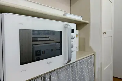 a microwave is attached to a wall in a kitchen at Colosseum Apartment Renovated Via Frangipane in Rome