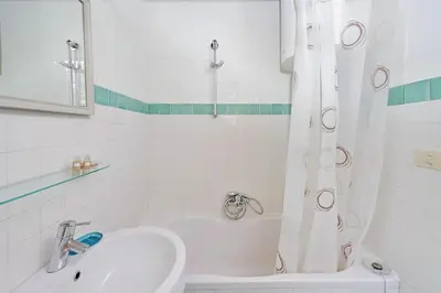a white bathroom with a sink and a shower at Colosseum Apartment Renovated Via Frangipane in Rome
