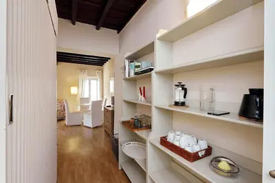 a room with white shelves and a living room at Colosseum Apartment Renovated Via Frangipane in Rome