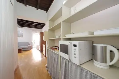 a kitchen with a microwave and a living room at Colosseum Apartment Renovated Via Frangipane in Rome