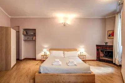 a bedroom with a large bed and a fireplace at Cappellari Campo dei Fiori int 2 in Rome