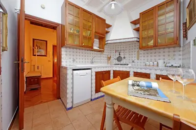 a kitchen with wooden cabinets and a table with wine glasses at Leutari in Rome