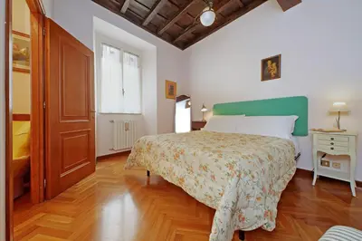 a bedroom with a large bed and a wooden floor at Leutari in Rome
