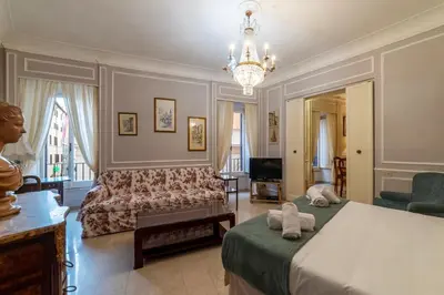 a bedroom with a bed and a couch and a chandelier at GuestHost - Piazza Navona Elegant Apartment in Rome