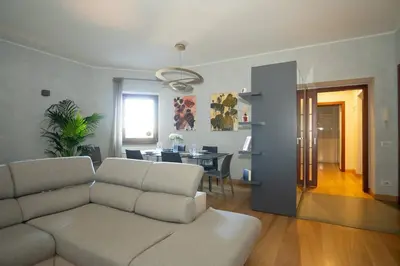 a living room with a couch and a dining room at Divine View Apartment in Rome