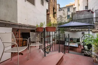 a patio with chairs and an umbrella on a balcony at Leonina Art House in Rome