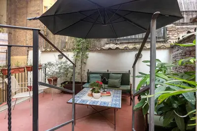 a patio with a table and an umbrella at Leonina Art House in Rome
