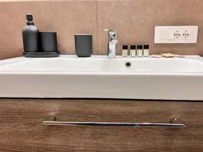 a bathroom sink with two bottles and a soap dispenser at La casa di Nina in Rome