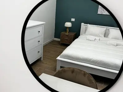 a bedroom with a white bed and a mirror at La casa di Nina in Rome