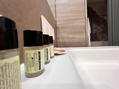 two bottles of moisturizers sitting on a counter next to a sink at La casa di Nina in Rome