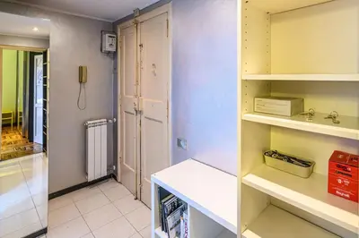 a small kitchen with white shelves and a phone at La Eterna Dimora in Rome
