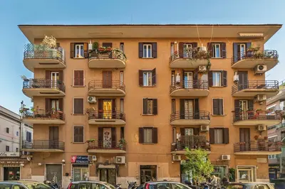 a building with balconies and cars parked in front of it at La Eterna Dimora in Rome