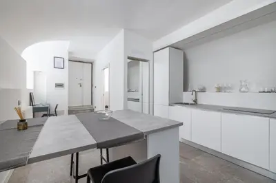 a kitchen with white cabinets and a table with chairs at Cecilia Guest House in Rome