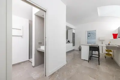 a white room with a desk and a table with a mirror at Cecilia Guest House in Rome