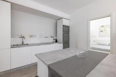 a kitchen with white cabinets and a bowl on a counter at Cecilia Guest House in Rome