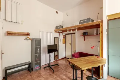 a living room with a wooden table and a desk at Cozy studio at pedestrian street in Rome