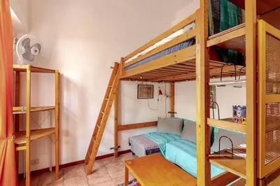 a room with a bunk bed and a couch at Cozy studio at pedestrian street in Rome