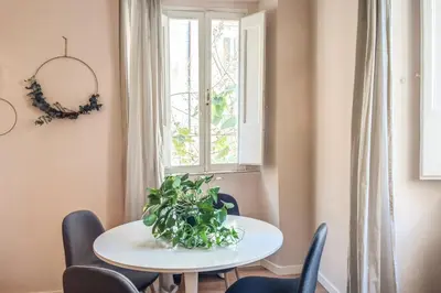 a table and chairs in a room with a window at Cappellari Campo dei Fiori int 3 in Rome