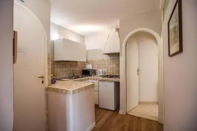 a kitchen with white appliances and an arched doorway at Cappellari Campo dei Fiori int 3 in Rome