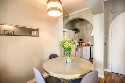 a dining room table with chairs and a vase of flowers at Cappellari Campo dei Fiori int 5 in Rome