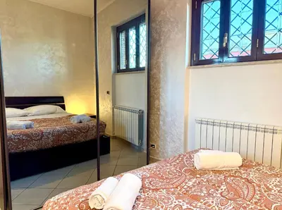 a bedroom with two beds and a mirror at Marconi Penthouse in Rome