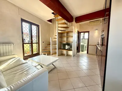 a living room with a couch and a table at Marconi Penthouse in Rome