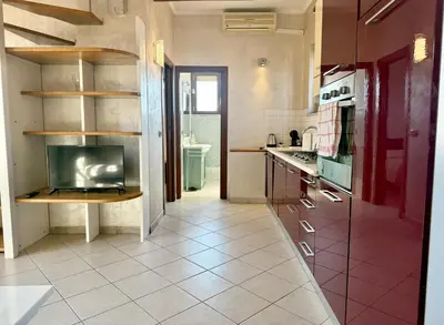 a kitchen with a sink and a tv on a shelf at Marconi Penthouse in Rome