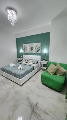 a bedroom with a large bed and a green couch at L'impero dei fiori in Rome