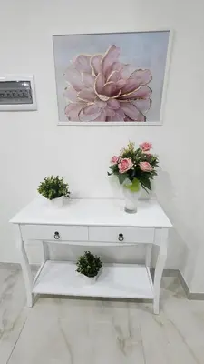 a white table with three flowers in vases on it at L'impero dei fiori in Rome