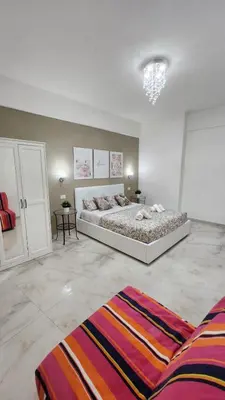 a white bedroom with a large bed and a rug at L'impero dei fiori in Rome