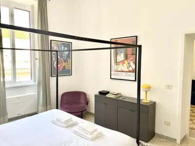 a bedroom with a bed and a purple chair at Colosseo Apartment - Domus Claudinae in Rome